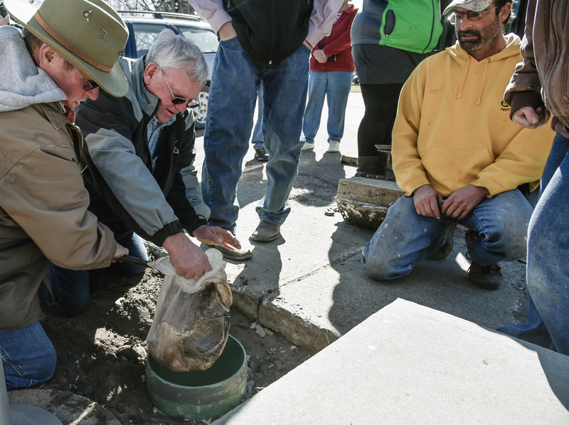 People in Burke, South Dakota pull out a soggy bag that was supposed to be a time capsule (Photo by Matt Gade/The Daily Republic)